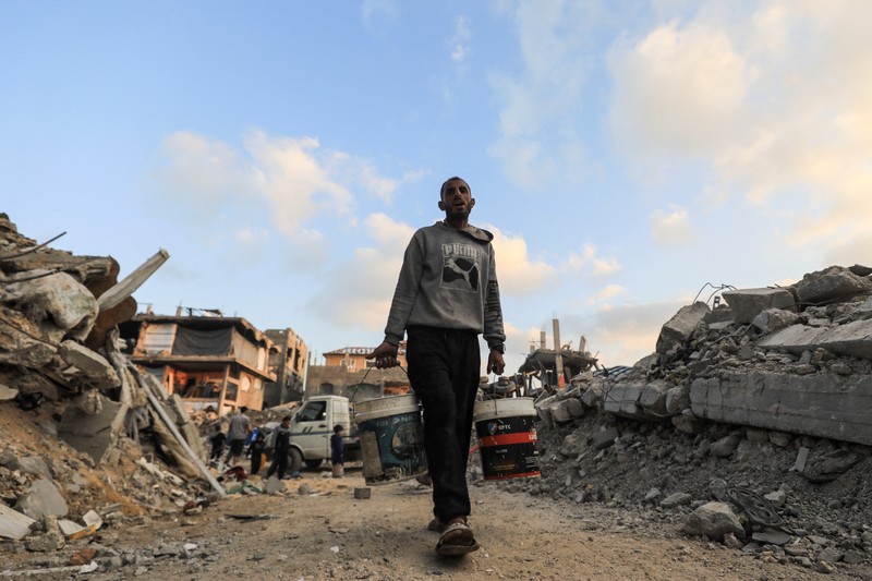 Seorang warga Palestina membawa air di tengah gencatan senjata antara Israel dan Hamas, di kamp pengungsi Jabalia di Jalur Gaza utara, 4 Februari 2025. (REUTERS/Mahmoud Issa)