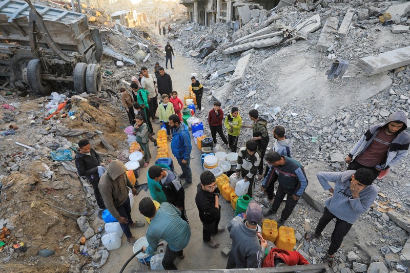 Seorang warga Palestina membawa air di tengah gencatan senjata antara Israel dan Hamas, di kamp pengungsi Jabalia di Jalur Gaza utara, 4 Februari 2025. (REUTERS/Mahmoud Issa)