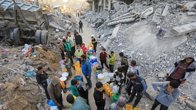 Seorang warga Palestina membawa air di tengah gencatan senjata antara Israel dan Hamas, di kamp pengungsi Jabalia di Jalur Gaza utara, 4 Februari 2025. (REUTERS/Mahmoud Issa)