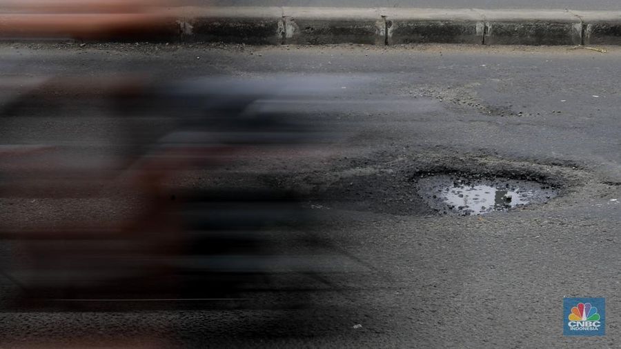 Pengendara melewati jalan rusak berlubang di Jalan Raya Parung-Ciputat, Bojongsari, Kota Depok, Jawa Barat, Jumat (7/1/2025). (CNBC Indonesia/Muhammad Sabki)