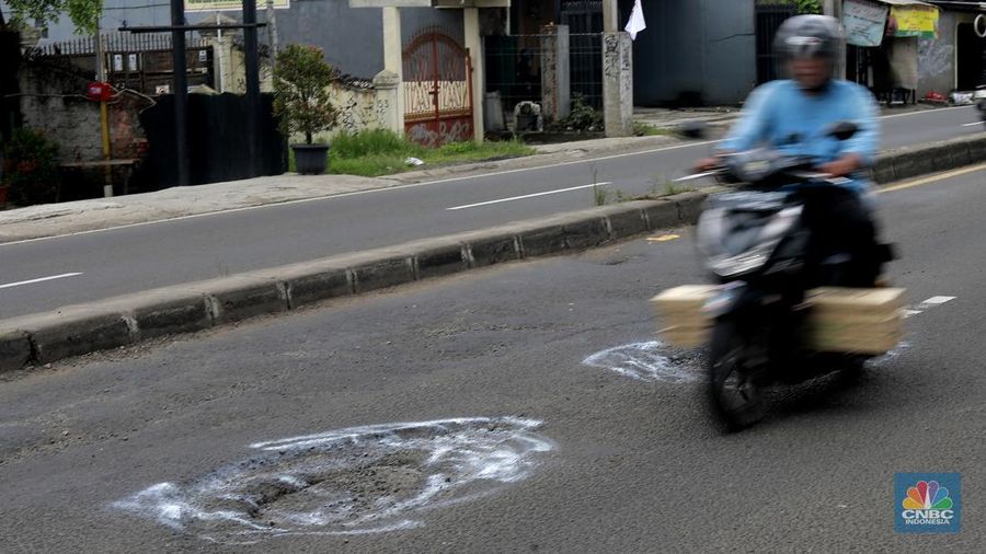 Pengendara melewati jalan rusak berlubang di Jalan Raya Parung-Ciputat, Bojongsari, Kota Depok, Jawa Barat, Jumat (7/1/2025). (CNBC Indonesia/Muhammad Sabki)