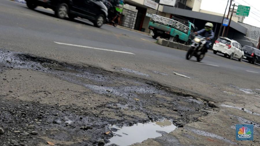 Pengendara melewati jalan rusak berlubang di Jalan Raya Parung-Ciputat, Bojongsari, Kota Depok, Jawa Barat, Jumat (7/1/2025). (CNBC Indonesia/Muhammad Sabki)