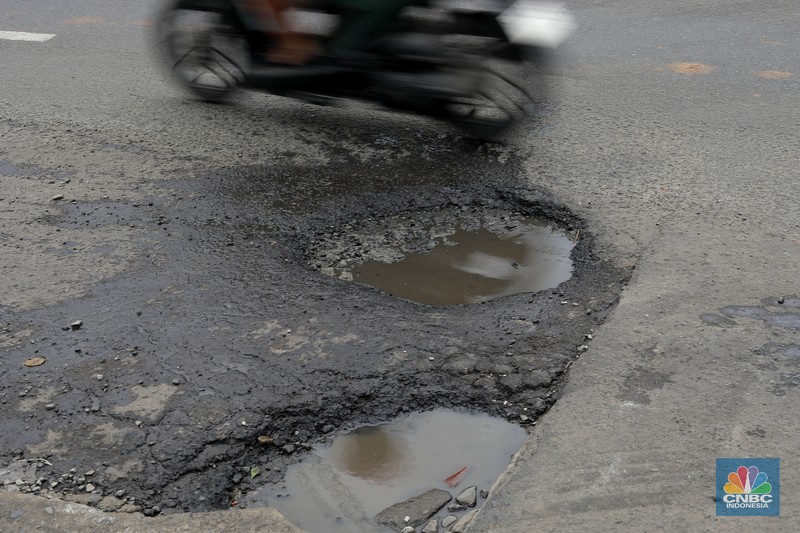 Pengendara melewati jalan rusak berlubang di Jalan Raya Parung-Ciputat, Bojongsari, Kota Depok, Jawa Barat, Jumat (7/1/2025). Pengendara melewati jalan rusak berlubang di Jalan Raya Parung-Ciputat, Bojongsari, Kota Depok, Jawa Barat, Jumat (7/1/2025). (CNBC Indonesia/Muhammad Sabki)
