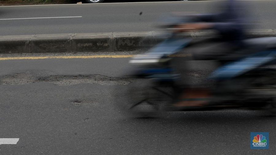 Pengendara melewati jalan rusak berlubang di Jalan Raya Parung-Ciputat, Bojongsari, Kota Depok, Jawa Barat, Jumat (7/1/2025). (CNBC Indonesia/Muhammad Sabki)