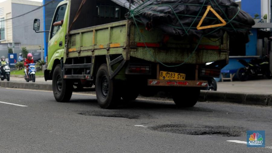 Pengendara melewati jalan rusak berlubang di Jalan Raya Parung-Ciputat, Bojongsari, Kota Depok, Jawa Barat, Jumat (7/1/2025). (CNBC Indonesia/Muhammad Sabki)