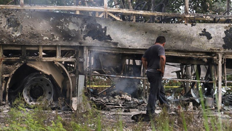 Sebuah bus yang terbakar terlihat setelah bertabrakan dengan sebuah trailer selama perjalanannya dari Cancun ke Tabasco, di mana orang-orang meninggal dalam kecelakaan itu, menurut media lokal, di dekat Escarcega, negara bagian Campeche di Meksiko selatan 8 Februari 2025. (REUTERS/Luis Manuel Lopez)