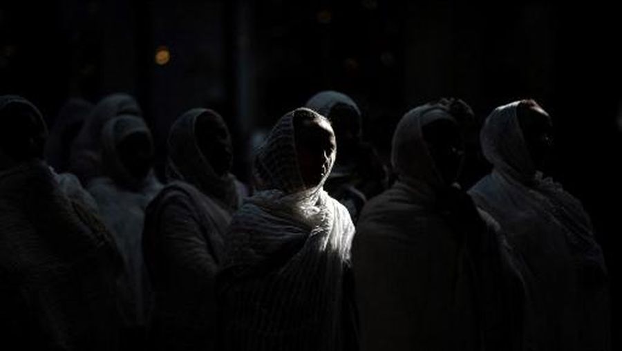 A faithful women looks as she attends a service to honour St George, at Saint George Eritrean Orthodox Church during their Easter celebrations, in Birmingham, central England, on May 11, 2024. (Photo by Oli SCARFF / AFP)