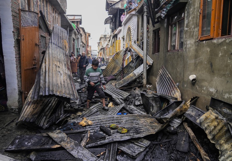 Seorang anak laki-laki Kashmir berjalan di atas puing-puing rumah yang rusak setelah kebakaran di rumah-rumah penduduk di Srinagar, Kashmir yang dikuasai India, Senin, 10 Februari 2025. Seorang anak laki-laki Kashmir berjalan di atas puing-puing rumah yang rusak setelah kebakaran di rumah-rumah penduduk di Srinagar, Kashmir yang dikuasai India, Senin, 10 Februari 2025. (AP Photo/Mukhtar Khan)