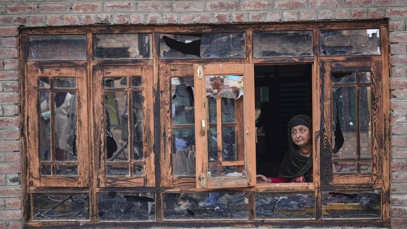 Seorang anak laki-laki Kashmir berjalan di atas puing-puing rumah yang rusak setelah kebakaran di rumah-rumah penduduk di Srinagar, Kashmir yang dikuasai India, Senin, 10 Februari 2025. (AP Photo/Mukhtar Khan)