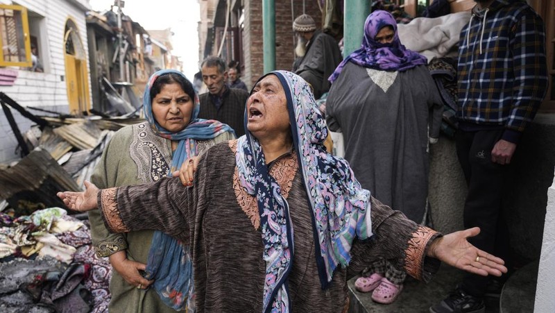 Seorang anak laki-laki Kashmir berjalan di atas puing-puing rumah yang rusak setelah kebakaran di rumah-rumah penduduk di Srinagar, Kashmir yang dikuasai India, Senin, 10 Februari 2025. (AP Photo/Mukhtar Khan)