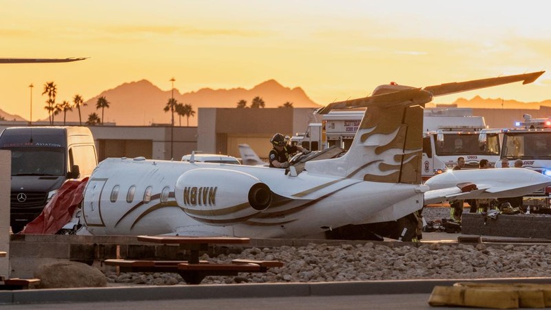 Petugas darurat menanggapi setelah jet bisnis ukuran sedang tergelincir dari landasan saat mendarat dan bertabrakan dengan jet lain yang diparkir di bandara kota di Scottsdale, Arizona, AS, 10 Februari 2025. (REUTERS/Thomas Machowicz)