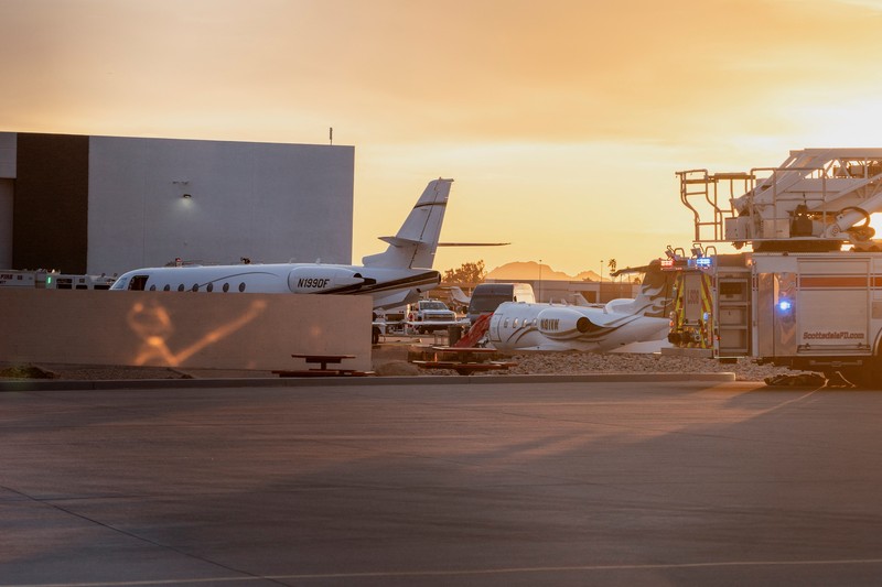 Petugas darurat menanggapi setelah jet bisnis ukuran sedang tergelincir dari landasan saat mendarat dan bertabrakan dengan jet lain yang diparkir di bandara kota di Scottsdale, Arizona, AS, 10 Februari 2025. (REUTERS/Thomas Machowicz)