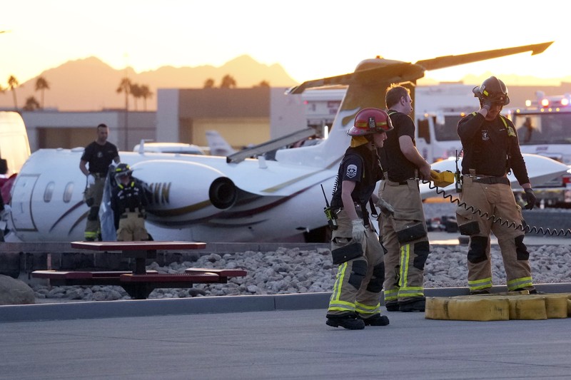 Petugas darurat menanggapi setelah jet bisnis ukuran sedang tergelincir dari landasan saat mendarat dan bertabrakan dengan jet lain yang diparkir di bandara kota di Scottsdale, Arizona, AS, 10 Februari 2025. (REUTERS/Thomas Machowicz)