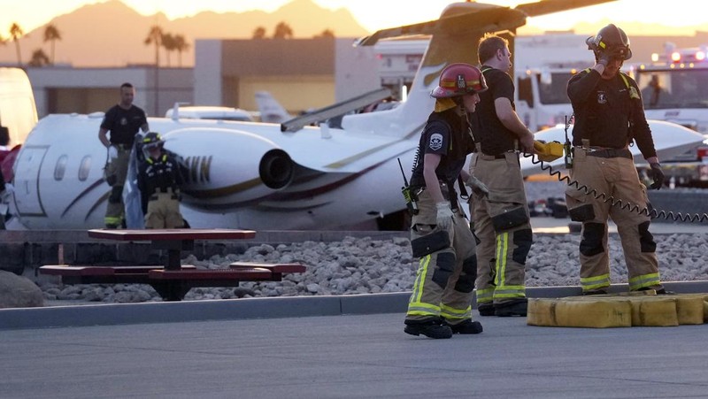 Petugas darurat menanggapi setelah jet bisnis ukuran sedang tergelincir dari landasan saat mendarat dan bertabrakan dengan jet lain yang diparkir di bandara kota di Scottsdale, Arizona, AS, 10 Februari 2025. (REUTERS/Thomas Machowicz)