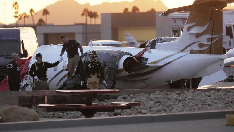 Petugas darurat menanggapi setelah jet bisnis ukuran sedang tergelincir dari landasan saat mendarat dan bertabrakan dengan jet lain yang diparkir di bandara kota di Scottsdale, Arizona, AS, 10 Februari 2025. (REUTERS/Thomas Machowicz)