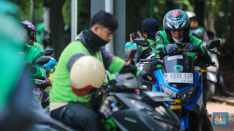 Pengemudi ojek online (ojol) menunggu orderan di kawasan Palmerah, Jakarta, Rabu (12/2/2025). Masyarakat Transportasi Indonesia (MTI) mengusulkan agar ojek online di Jakarta bisa mendapatkan bahan bakar minyak (BBM) subsidi dengan cara menggunakan plat kuning dalam upaya mendorong masyarakat untuk beralih ke angkutan umum. (CNBC Indonesia/Faisal Rahman)