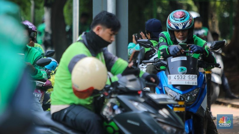 Pengemudi ojek online (ojol) menunggu orderan di kawasan Palmerah, Jakarta, Rabu (12/2/2025). Masyarakat Transportasi Indonesia (MTI) mengusulkan agar ojek online di Jakarta bisa mendapatkan bahan bakar minyak (BBM) subsidi dengan cara menggunakan plat kuning dalam upaya mendorong masyarakat untuk beralih ke angkutan umum. (CNBC Indonesia/Faisal Rahman)