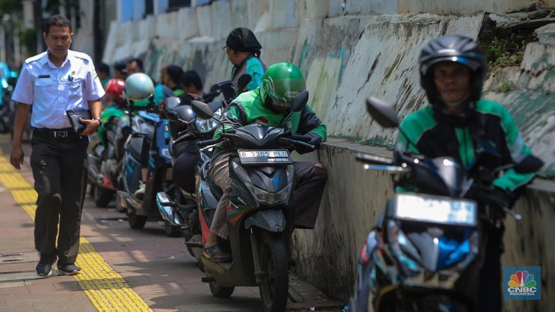 Pengemudi ojek online (ojol) menunggu orderan di kawasan Palmerah, Jakarta, Rabu (12/2/2025). Masyarakat Transportasi Indonesia (MTI) mengusulkan agar ojek online di Jakarta bisa mendapatkan bahan bakar minyak (BBM) subsidi dengan cara menggunakan plat kuning dalam upaya mendorong masyarakat untuk beralih ke angkutan umum. (CNBC Indonesia/Faisal Rahman)