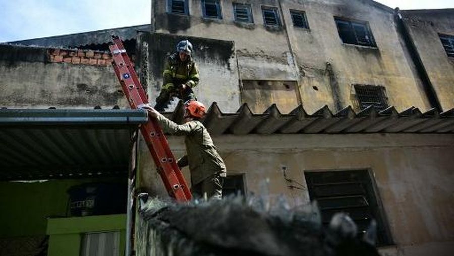 Firefighters leave after extinguishing a fire in a textile factory specialized in making carnival costumes and police uniforms in the northern part of Rio de Janeiro, Brazil, on February 12, 2025. At least 10 people were injured Wednesday in a fire at a clothing factory in Rio de Janeiro which was making costumes for the city's famed carnival, a local health official said. (Photo by Mauro PIMENTEL / AFP)