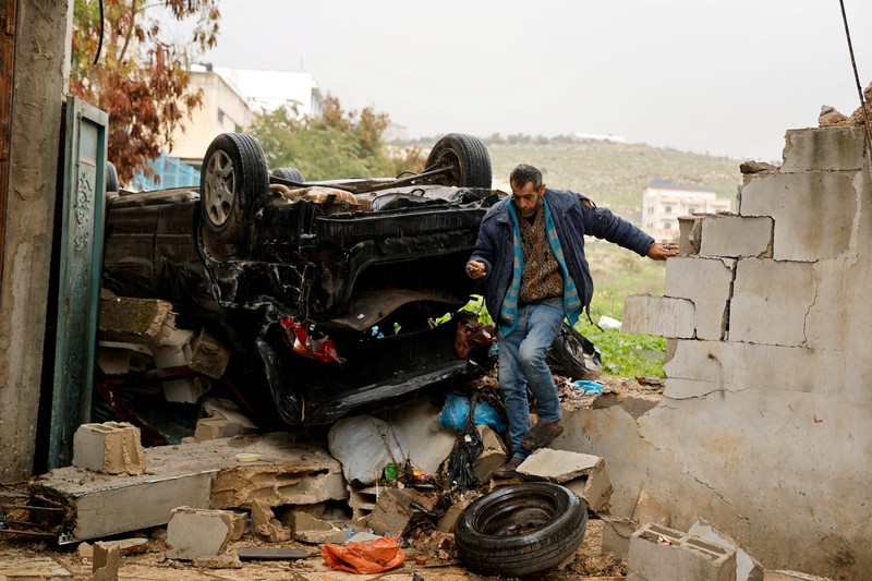 Palestinians remove the rubble from a damaged building in the aftermath of an Israeli raid, in Al-Faraa refugee camp near Tubas, in the Israeli-occupied West Bank, February 12, 2025. REUTERS/Raneen Sawafta