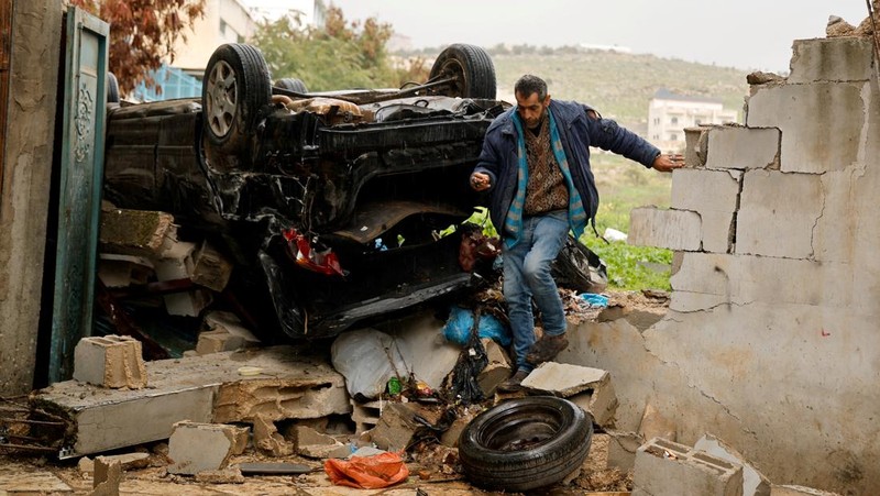 Palestinians remove the rubble from a damaged building in the aftermath of an Israeli raid, in Al-Faraa refugee camp near Tubas, in the Israeli-occupied West Bank, February 12, 2025. REUTERS/Raneen Sawafta