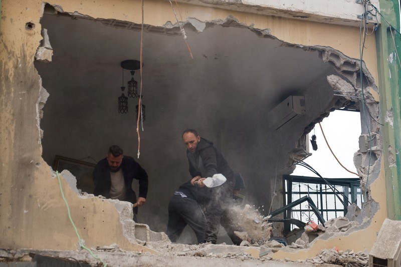 ISRAEL-PALESTINIANS/WEST BANK-AFTERMATH Palestinians remove the rubble from a damaged building in the aftermath of an Israeli raid, in Al-Faraa refugee camp near Tubas, in the Israeli-occupied West Bank, February 12, 2025. REUTERS/Raneen Sawafta