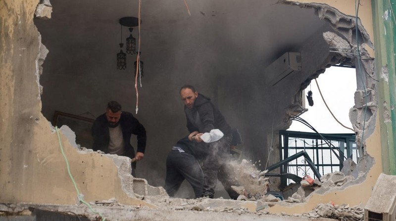 Palestinians remove the rubble from a damaged building in the aftermath of an Israeli raid, in Al-Faraa refugee camp near Tubas, in the Israeli-occupied West Bank, February 12, 2025. REUTERS/Raneen Sawafta