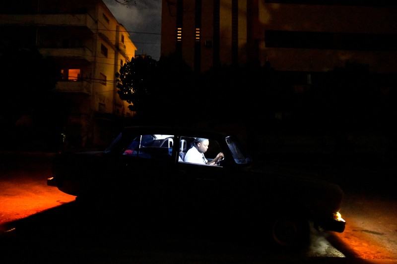 People sit outside their home during a blackout following the failure of a major power plant, Havana, Cuba February 13, 2025. REUTERS/Norlys Perez