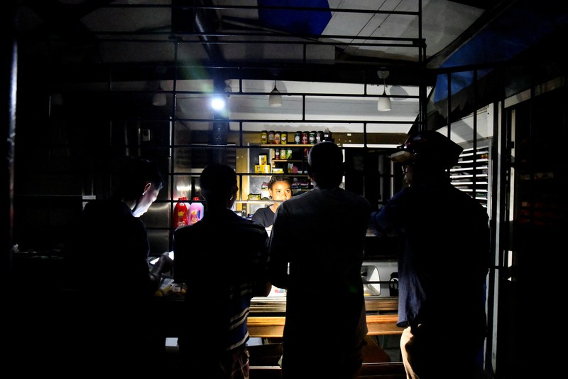 People sit outside their home during a blackout following the failure of a major power plant, Havana, Cuba February 13, 2025. REUTERS/Norlys Perez