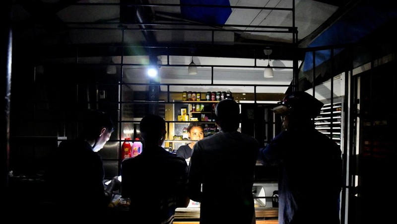 People sit outside their home during a blackout following the failure of a major power plant, Havana, Cuba February 13, 2025. REUTERS/Norlys Perez