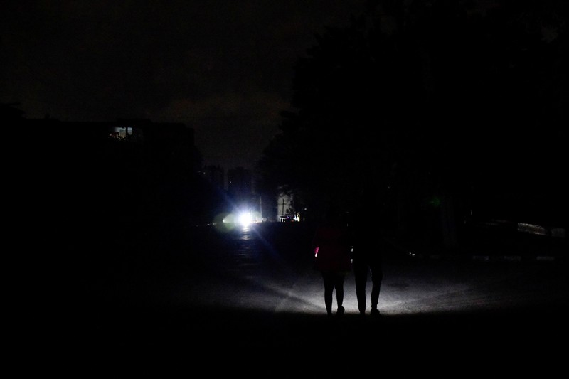 People sit outside their home during a blackout following the failure of a major power plant, Havana, Cuba February 13, 2025. REUTERS/Norlys Perez