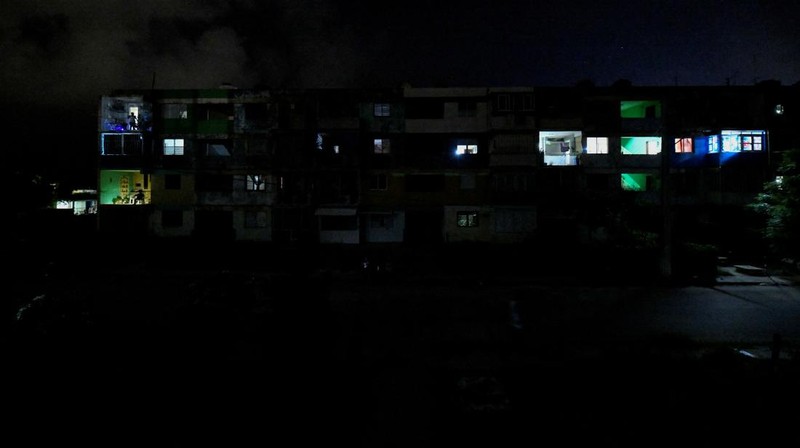 People sit outside their home during a blackout following the failure of a major power plant, Havana, Cuba February 13, 2025. REUTERS/Norlys Perez