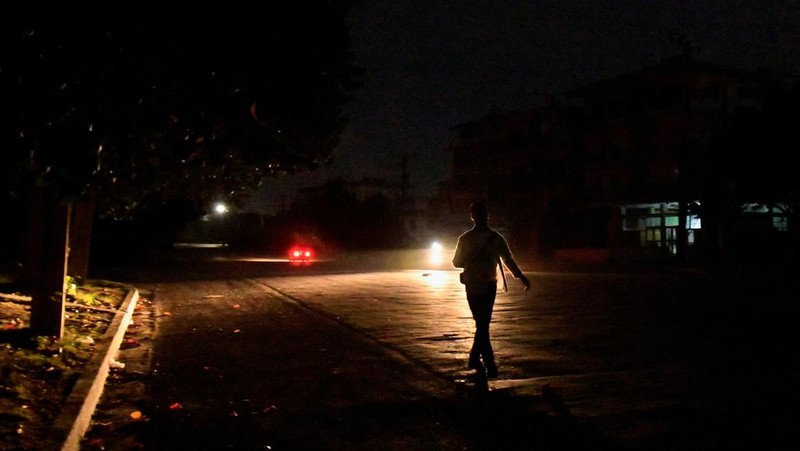 People sit outside their home during a blackout following the failure of a major power plant, Havana, Cuba February 13, 2025. REUTERS/Norlys Perez