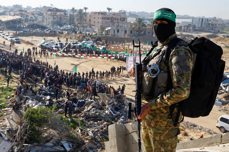 ISRAEL-PALESTINIANS/GAZA-CEASEFIRE A drone view shows Palestinian Hamas and Islamic Jihad militants escorting Iair Horn, U.S.-Israeli Sagui Dekel-Chen and Russian-Israeli Sasha (Alexander) Troufanov, hostages held in Gaza since the deadly October 7, 2023 attack, as they released as part of a ceasefire and a hostages-prisoners swap deal between Hamas and Israel in Khan Younis, in the southern Gaza Strip, February 15, 2025. REUTERS/Stringer