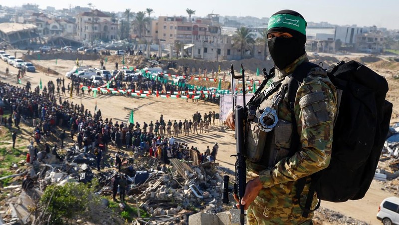 A drone view shows Palestinian Hamas and Islamic Jihad militants escorting Iair Horn, U.S.-Israeli Sagui Dekel-Chen and Russian-Israeli Sasha (Alexander) Troufanov, hostages held in Gaza since the deadly October 7, 2023 attack, as they released as part of a ceasefire and a hostages-prisoners swap deal between Hamas and Israel in Khan Younis, in the southern Gaza Strip, February 15, 2025. REUTERS/Stringer