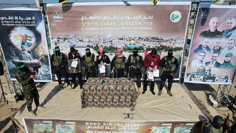 A drone view shows Palestinian Hamas and Islamic Jihad militants escorting Iair Horn, U.S.-Israeli Sagui Dekel-Chen and Russian-Israeli Sasha (Alexander) Troufanov, hostages held in Gaza since the deadly October 7, 2023 attack, as they released as part of a ceasefire and a hostages-prisoners swap deal between Hamas and Israel in Khan Younis, in the southern Gaza Strip, February 15, 2025. REUTERS/Stringer