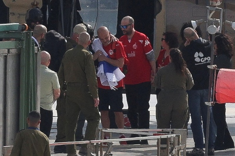 A drone view shows Palestinian Hamas and Islamic Jihad militants escorting Iair Horn, U.S.-Israeli Sagui Dekel-Chen and Russian-Israeli Sasha (Alexander) Troufanov, hostages held in Gaza since the deadly October 7, 2023 attack, as they released as part of a ceasefire and a hostages-prisoners swap deal between Hamas and Israel in Khan Younis, in the southern Gaza Strip, February 15, 2025. REUTERS/Stringer