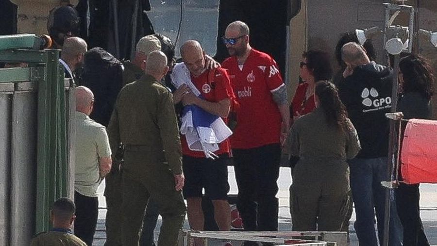 A drone view shows Palestinian Hamas and Islamic Jihad militants escorting Iair Horn, U.S.-Israeli Sagui Dekel-Chen and Russian-Israeli Sasha (Alexander) Troufanov, hostages held in Gaza since the deadly October 7, 2023 attack, as they released as part of a ceasefire and a hostages-prisoners swap deal between Hamas and Israel in Khan Younis, in the southern Gaza Strip, February 15, 2025. REUTERS/Stringer