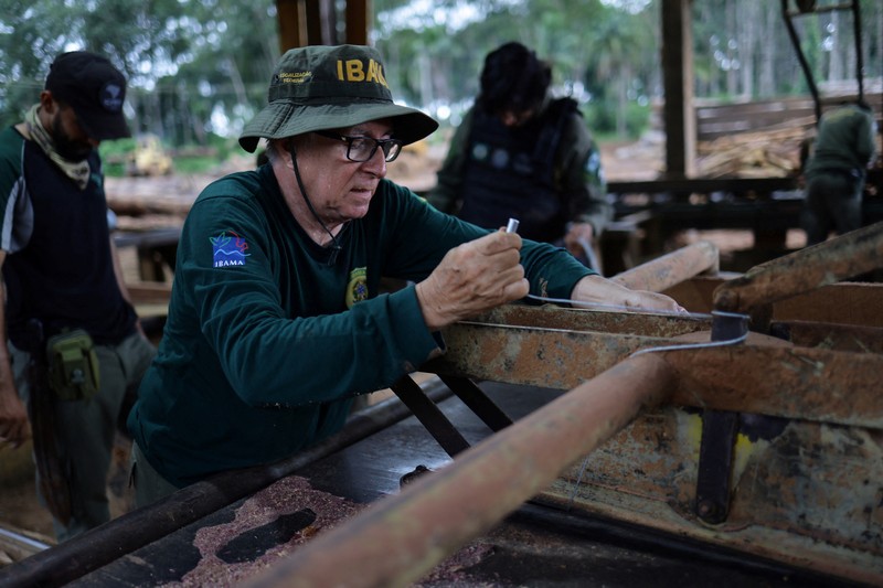 Jair Schmitt, direktur Perlindungan Lingkungan di Institut Brasil untuk Lingkungan dan Sumber Daya Alam Terbarukan (IBAMA), memeriksa kayu gelondongan yang disita dari hutan hujan Amazon selama operasi pemberantasan deforestasi, di tempat penggergajian kayu di Nova California, Negara Bagian Rondonia, Brasil, 5 Februari 2025. Jair Schmitt, direktur Perlindungan Lingkungan di Institut Brasil untuk Lingkungan dan Sumber Daya Alam Terbarukan (IBAMA), memeriksa kayu gelondongan yang disita dari hutan hujan Amazon selama operasi pemberantasan deforestasi, di tempat penggergajian kayu di Nova California, Negara Bagian Rondonia, Brasil, 5 Februari 2025. (REUTERS/Ueslei Marcelino)