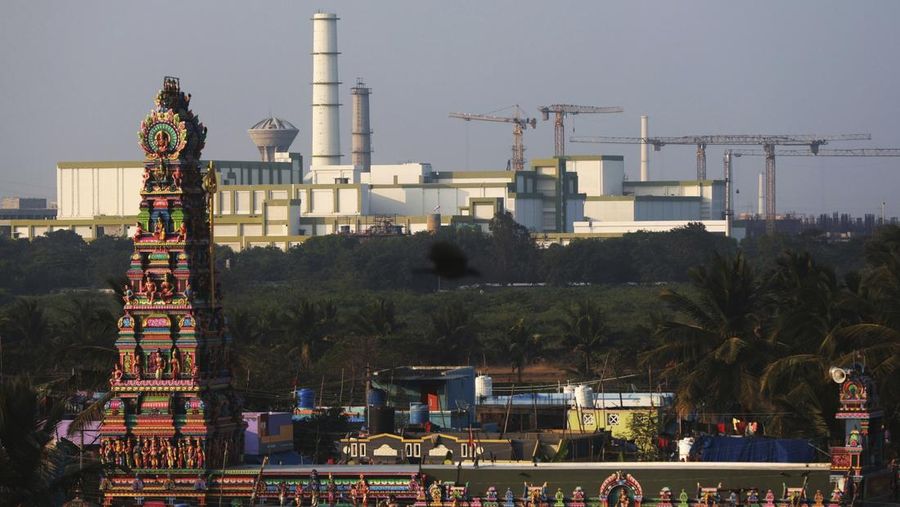Sebuah kuil berdiri di latar depan Pembangkit Listrik Tenaga Atom Madras yang terletak di Kalpakkam di negara bagian Tamil Nadu, India, Senin, 10 Februari 2025. (AP Photo/R. Parthibhan)