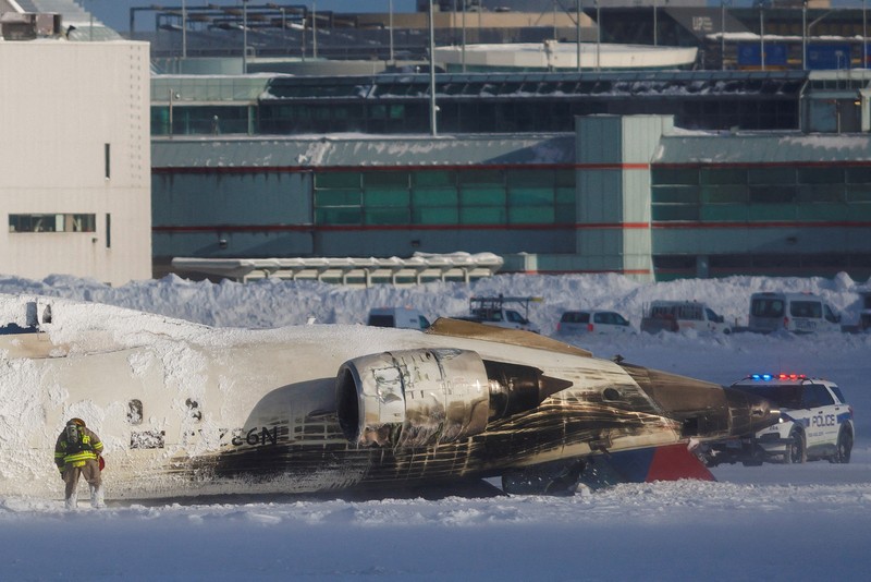 Petugas pemadam kebakaran Bandara Internasional Pearson bekerja pada pesawat Delta Air Lines yang terbalik, yang sedang dalam perjalanan dari Minneapolis ke Toronto ketika jatuh di landasan pacu, di Toronto, Senin, 17 Februari 2025. Petugas pemadam kebakaran Bandara Internasional Pearson bekerja pada pesawat Delta Air Lines yang terbalik, yang sedang dalam perjalanan dari Minneapolis ke Toronto ketika jatuh di landasan pacu, di Toronto, Senin, 17 Februari 2025. (Teresa Barbieri/The Canadian Press via AP)