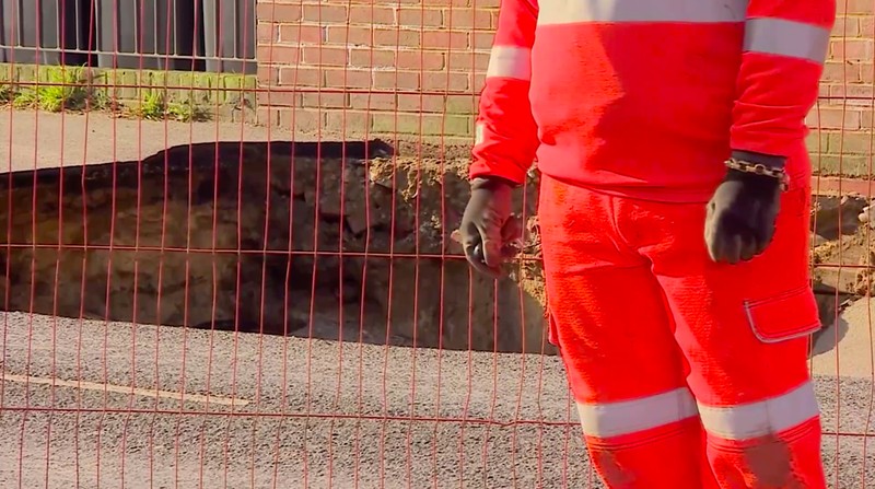 Sebuah lubang besar memicu evakuasi pada hari Selasa (18 /2/2025) di Godstone, sebuah desa dekat London. (Tangkapan Layar Video Reuters/BBC)