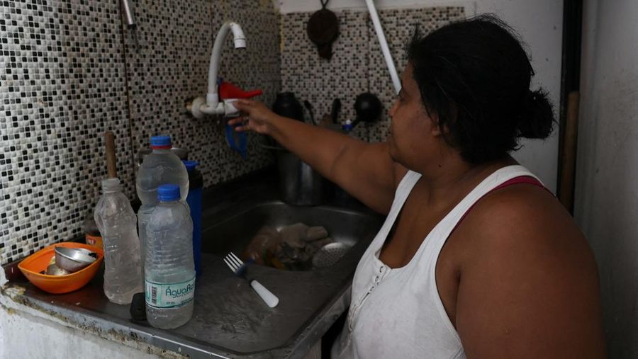 Dayana da Silva, 38, menunjukkan kehabisan air di rumahnya di tengah gelombang panas ekstrem di daerah kumuh Jacarezinho di Rio de Janeiro, Brasil, 18 Februari 2025. (REUTERS/Aline Massuca)