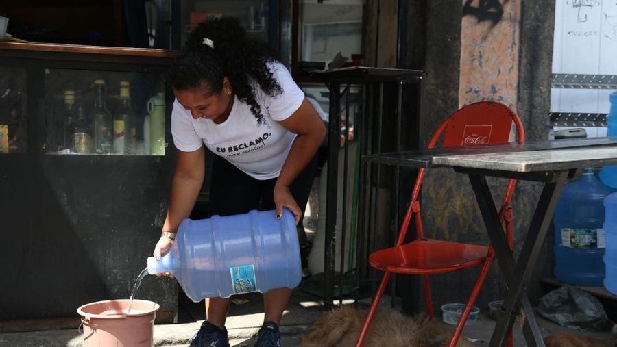 Dayana da Silva, 38, menunjukkan kehabisan air di rumahnya di tengah gelombang panas ekstrem di daerah kumuh Jacarezinho di Rio de Janeiro, Brasil, 18 Februari 2025. (REUTERS/Aline Massuca)