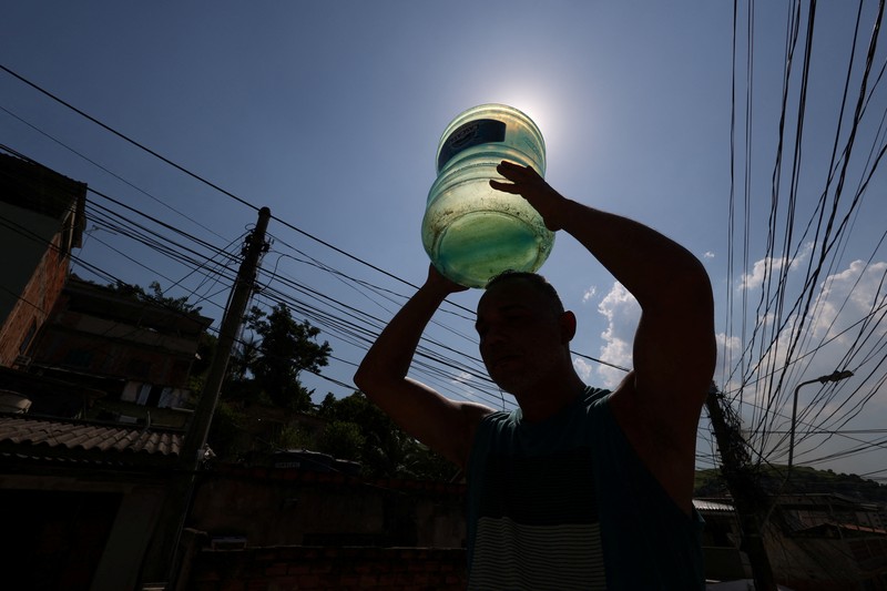 Dayana da Silva, 38, menunjukkan kehabisan air di rumahnya di tengah gelombang panas ekstrem di daerah kumuh Jacarezinho di Rio de Janeiro, Brasil, 18 Februari 2025. (REUTERS/Aline Massuca)