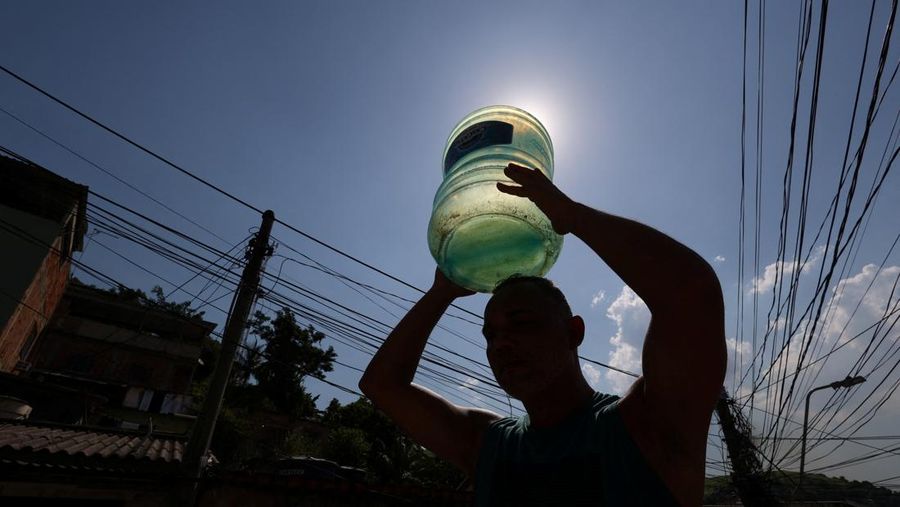 Dayana da Silva, 38, menunjukkan kehabisan air di rumahnya di tengah gelombang panas ekstrem di daerah kumuh Jacarezinho di Rio de Janeiro, Brasil, 18 Februari 2025. (REUTERS/Aline Massuca)