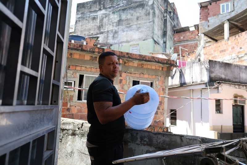 Dayana da Silva, 38, menunjukkan kehabisan air di rumahnya di tengah gelombang panas ekstrem di daerah kumuh Jacarezinho di Rio de Janeiro, Brasil, 18 Februari 2025. (REUTERS/Aline Massuca)