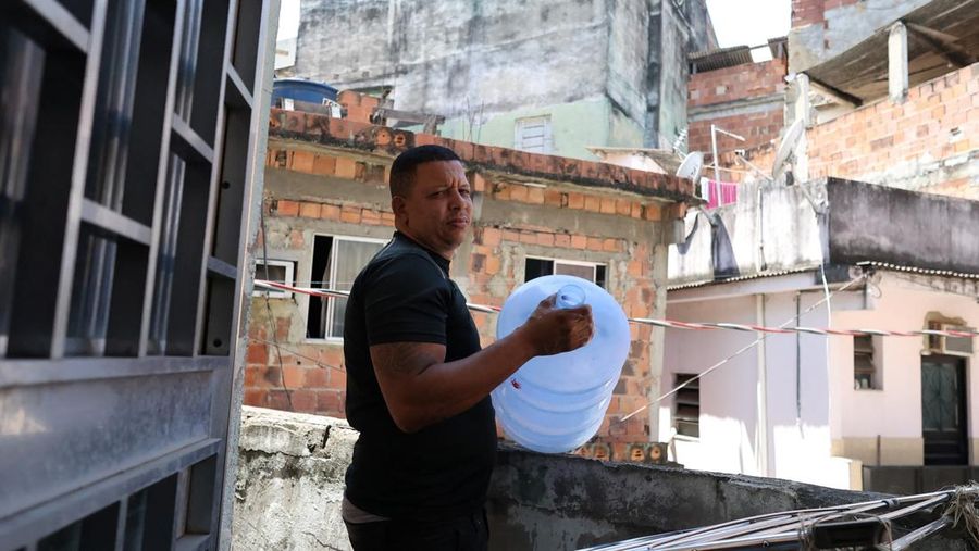 Dayana da Silva, 38, menunjukkan kehabisan air di rumahnya di tengah gelombang panas ekstrem di daerah kumuh Jacarezinho di Rio de Janeiro, Brasil, 18 Februari 2025. (REUTERS/Aline Massuca)