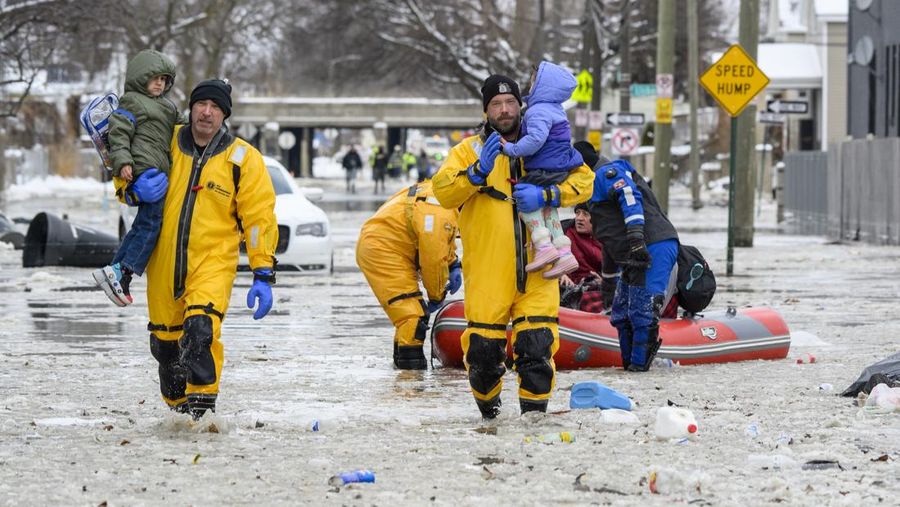 Sebuah truk pemuat depan melaju di Green Street setelah pipa air utama pecah di Detroit yang menyebabkan banjir besar dan memicu evakuasi, Senin, 17 Februari 2025. (Andy Morrison/Detroit News via AP)