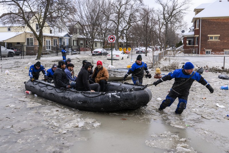 Sebuah truk pemuat depan melaju di Green Street setelah pipa air utama pecah di Detroit yang menyebabkan banjir besar dan memicu evakuasi, Senin, 17 Februari 2025. (Andy Morrison/Detroit News via AP)